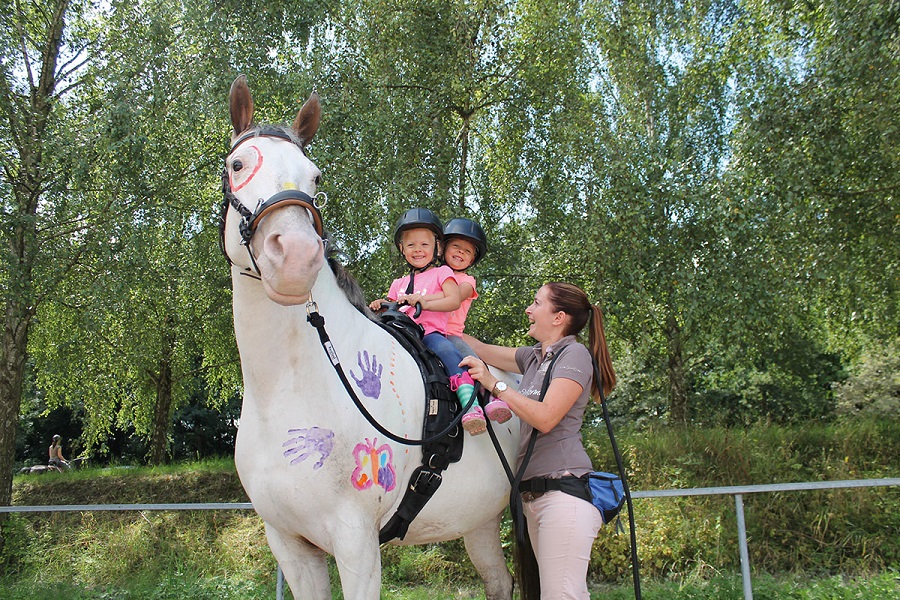 Szép ló Barefoot felszereléssel és két kisgyerekkel a hátán
